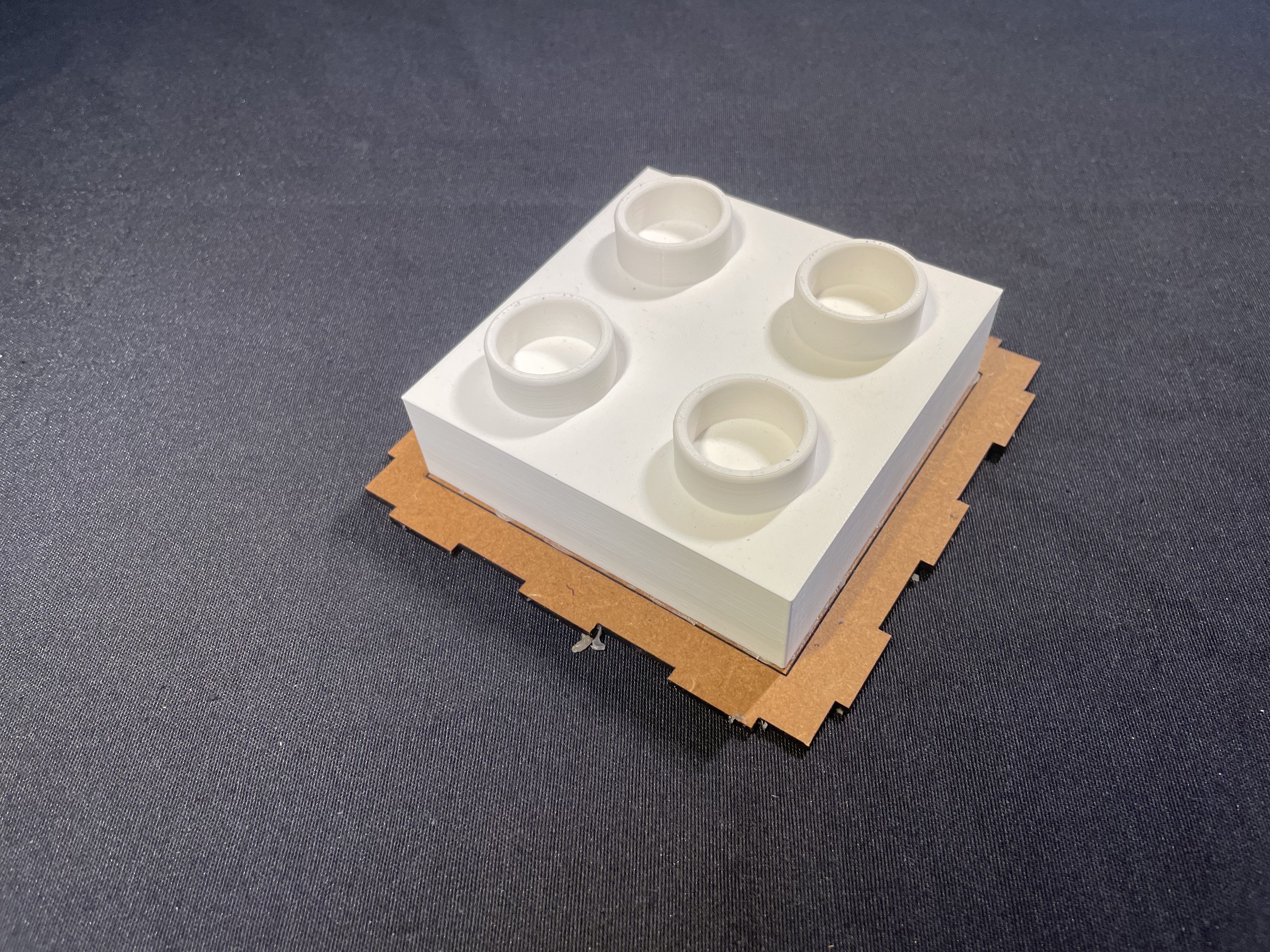 3D printed mold master with four cylindrical inserts.