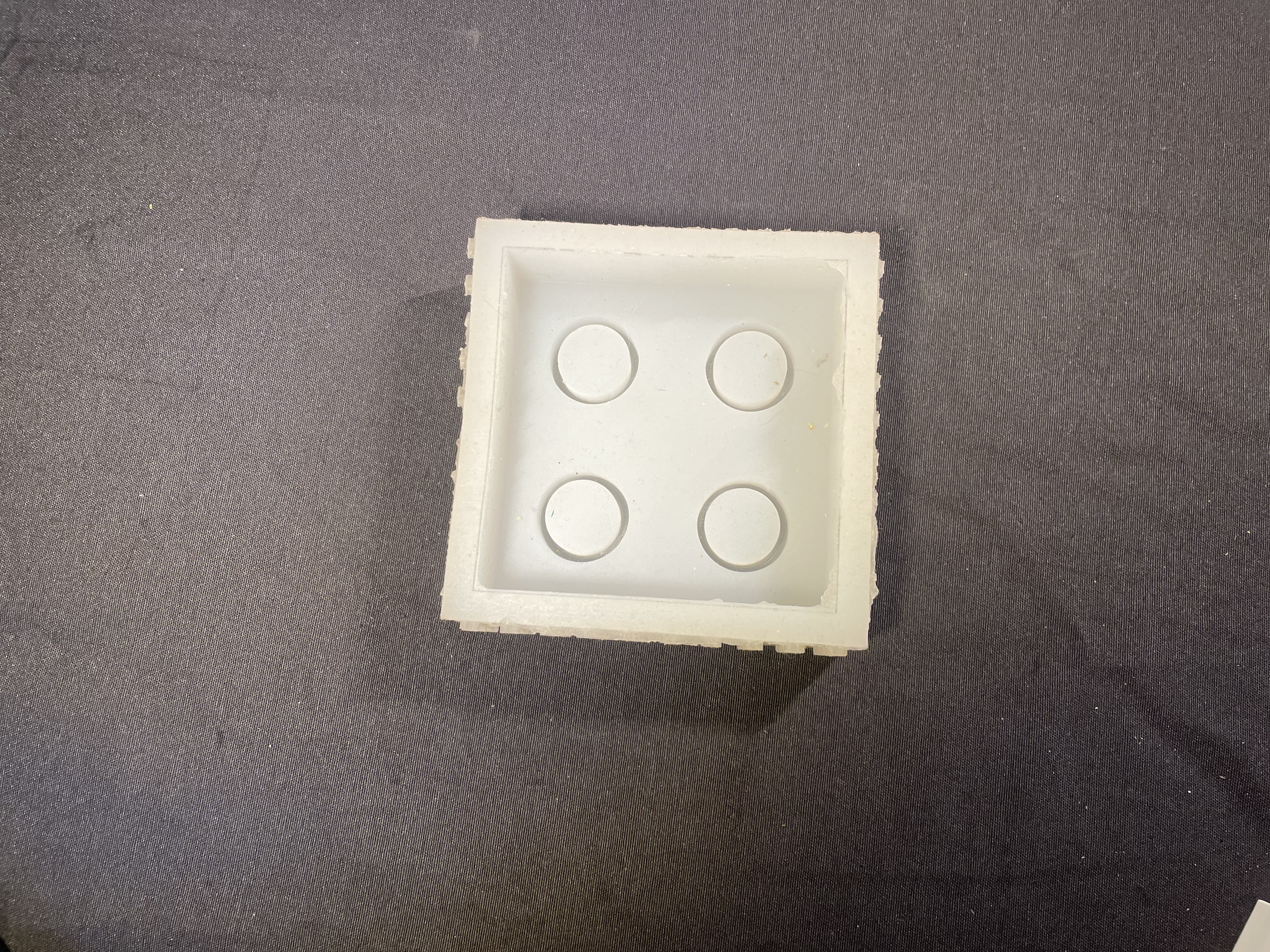 3D printed mold master with four circular cavities.